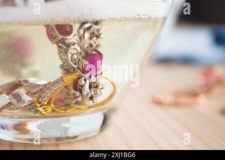 Reinigung Vintage Schmuck Diamant Ring und Armband in Glas auf Holztischhintergrund Stockfoto