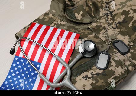 Stethoskop, US-Flagge, Tags und Militäruniform auf weißem Holztisch Stockfoto