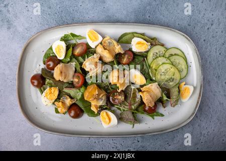 Warmer Salat mit Raps (Schnecken), Tomaten, Gurken, Blattgemüse, Wachteleiern und Olivenöl. Traditioneller Salat mit Meeresfrüchten. Nahaufnahme, selektiver Fokus. Stockfoto