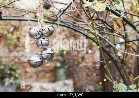 Weihnachtssilberglocken hängen in einem rustikalen Garten. Stockfoto