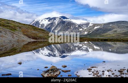 Schneebedecktes Besshoe 2258 m mit seinem kleinen Gletscher Besshoebrean vom Bessvatnet See im Jotunheimen Nationalpark in Zentral-Norwegen Stockfoto
