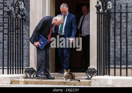 London, Großbritannien. Juli 2024. Hilary Benn Abgeordneter (l), Secretary of State for Northern Ireland, und Steve Reed OBE Abgeordneter (r), Secretary of State for Environment, Food and Rural Affairs, nähern sich Larry, der Katze, als sie die Downing Street 10 nach einer Kabinettssitzung verlassen. Der britische Premierminister Sir Keir Starmer hat geraten, dass sein neues Kabinett mit dem Schwerpunkt auf der Lieferung „auf den Boden gehen“ muss. Quelle: Mark Kerrison/Alamy Live News Stockfoto