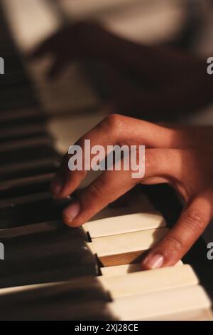 Ein fesselndes Bild der Hände eines schwarzen Mannes, das ein altes Honky Tonk Klavier spielt, aufgenommen mit einer großen Blende. Diese Szene verkörpert Kreativität und Inspiration Stockfoto