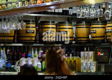 Sevilla, Spanien. 5. Februar 2024 - Holzfässer hinter einer Theke im mercado de triana Stockfoto