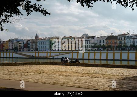 Sevilla, Spanien. 7. Februar 2024 - Sevillas Stadtbild mit entspannenden Menschen am Fluss Stockfoto