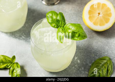 Erfrischendes Boozy Basil Gin Smash mit Limette Stockfoto