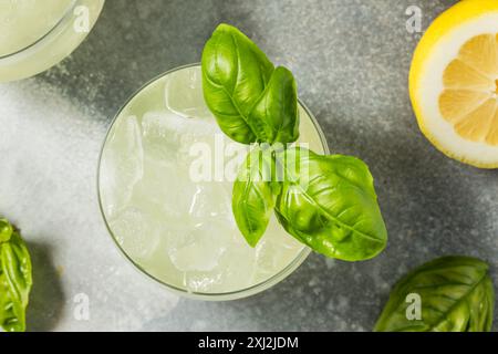 Erfrischendes Boozy Basil Gin Smash mit Limette Stockfoto