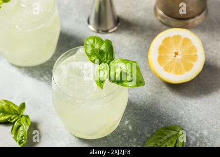 Erfrischendes Boozy Basil Gin Smash mit Limette Stockfoto