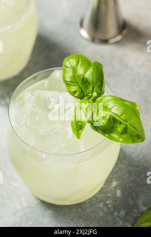 Erfrischendes Boozy Basil Gin Smash mit Limette Stockfoto