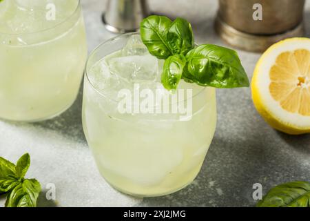 Erfrischendes Boozy Basil Gin Smash mit Limette Stockfoto