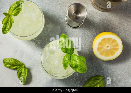 Erfrischendes Boozy Basil Gin Smash mit Limette Stockfoto