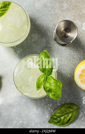 Erfrischendes Boozy Basil Gin Smash mit Limette Stockfoto