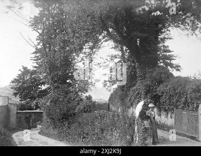 Eine Dame mit einem Sonnenschirm auf einem Weg, der zur Rapparee Cove führt, Ilfracombe, Devon. Dieses Foto stammt von einem edwardianischen Original, um 1910. Das Original war Teil eines Albums von 150 Albumenfotos von unterschiedlicher Qualität, von denen ich viele fotografiert habe. Die Sammlung enthielt Bilder vor allem von der Isle of man und der englischen Grafschaft Devonshire. Anmerkungen waren im Album enthalten, aber leider gab es keine genauen Daten. Die Originalfotos waren durchschnittlich 6 x 4 ½ Zoll. Stockfoto