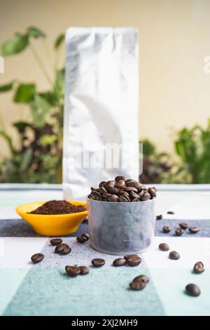 Kaffeebeutel-Paket Mockup mit Espresso Americano und Cofee-Bohnen, gemahlenem Kaffee auf Gartentisch Stockfoto