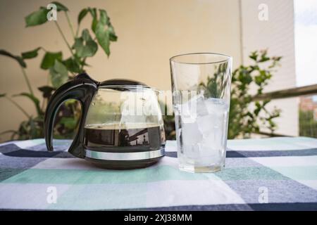 Ein großes Glas mit Eis und Kaffeekanne an der Seite für Cold Brew Americano im Sommer im Café Stockfoto