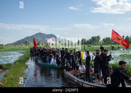 Srinagar, Indien. Juli 2024. Kaschmiri schiitische Trauer bewegen sich in Booten während der Prozession im Inneren des Dal-Sees in Srinagar am 9. Muharram, dem ersten und heiligsten Monat des islamischen Kalenders. Schiitische Muslime gedenken Muharram als einen Monat der Trauer zum Gedenken an das Martyrium des Enkels des islamischen Propheten Muhammad, Imam Hussain, der zusammen mit seinen Familienmitgliedern in der Schlacht von Karbala im südlichen Irak im Jahr 680 n. Chr. getötet wurde Credit: SOPA Images Limited/Alamy Live News Stockfoto