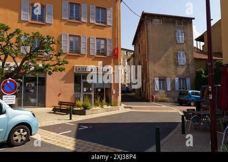 Langeac, Frankreich - 28. Mai 2023: Eine charmante Straßenecke in Langeac, Frankreich, mit einer Bank und einem Baum. Der sonnige Tag ist lang Stockfoto