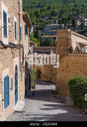 Atemberaubendes Stadtbild des kleinen Küstendorfes Deia auf Mallorca, Spanien. Traditionelle Häuser, enge Straße, am Ende der Straße ist ein Gelb Stockfoto