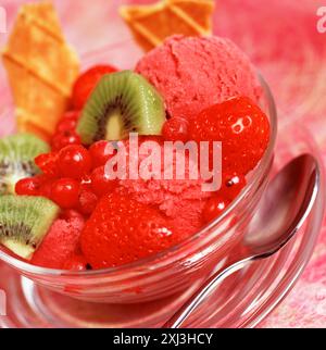Eis und Obst in einer Glasschale Stockfoto