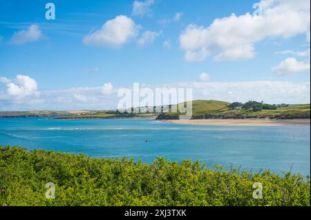 Blick von Padstow über die Kamelmündung in Richtung Daymer Bay. Kleine Wellen, die über der gefährlichen Doom Bar Sandbank Cornwall England UK brechen Stockfoto