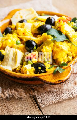 Vegetarische Paella mit Artischocken, schwarzen Oliven, grünen Bohnen und Paprika Stockfoto