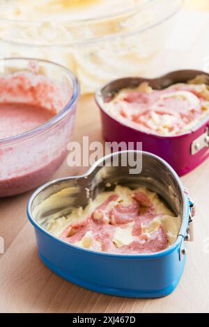 Füllen Sie Springform-Pfannen mit Teig für einen Erdbeerkuchen Stockfoto