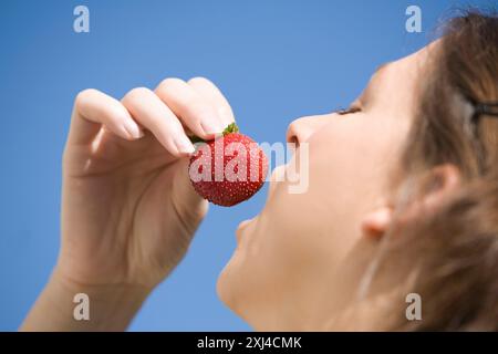Frau eine Erdbeere essen Stockfoto