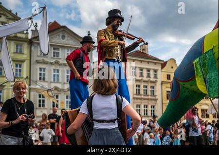 Der Künstler spielt Geige, während er während des Prager Straßentheaters Festival B auf Stelzen auf der Marionettenparade vom Marián-Platz zum Altstädter Ring spaziert Stockfoto