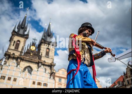 Der Künstler spielt Geige, während er während des Prager Straßentheaters Festival B auf Stelzen auf der Marionettenparade vom Marián-Platz zum Altstädter Ring spaziert Stockfoto