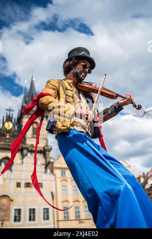 Der Künstler spielt Geige, während er während des Prager Straßentheaters Festival B auf Stelzen auf der Marionettenparade vom Marián-Platz zum Altstädter Ring spaziert Stockfoto