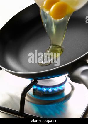 Eier in eine Pfanne geben Stockfoto