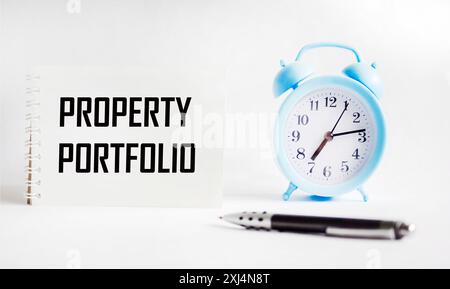 Symbol für Immobilienportfolio. Konzeptionelle Begriffe Immobilienportfolio auf einem Notizblock. Schwarzer Stift und Uhr. Portfoliokonzept für gewerbliche Immobilien. Stockfoto