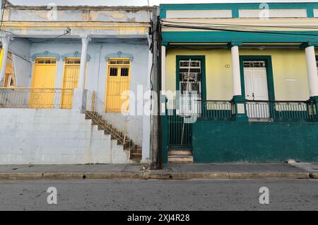 509 Ineinstöckige Kolonialstädte mit blassblauen und zitronengelben Fassaden, weißen und auffälligen gelben Türen, CLARIN-Padre Quiroga Street. Santiago-Cub Stockfoto