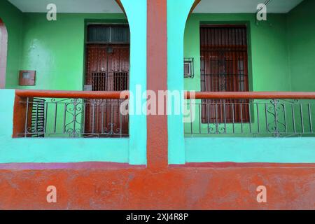 517 einstöckige Kolonialhausfassade mit mintgrüner und kastanienroter Wand, runder bogenförmiger Eingangsportal, Heredia Street Südseite. Santiago-Kuba. Stockfoto