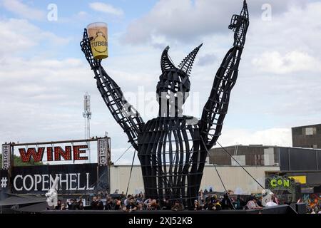 Kopenhagen, Dänemark - 19. Juni 2024: Festivalbesucher vor dem Logo beim Copenhell Metal Festival auf dem Kloverparken Camping Kopenhagen, Dänemark. Stockfoto