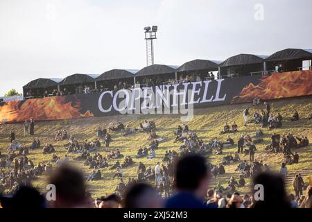 Kopenhagen, Dänemark - 19. Juni 2024: Festivalbesucher vor dem Logo beim Copenhell Metal Festival auf dem Kloverparken Camping Kopenhagen, Dänemark. Stockfoto