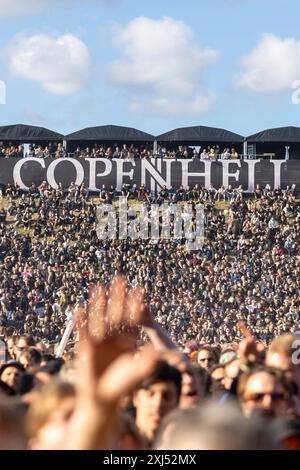 Kopenhagen, Dänemark - 19. Juni 2024: Festivalbesucher vor dem Logo beim Copenhell Metal Festival auf dem Kloverparken Camping Kopenhagen, Dänemark. Stockfoto