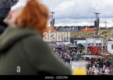 Kopenhagen, Dänemark - 19. Juni 2024: Festivalbesucher vor dem Logo beim Copenhell Metal Festival auf dem Kloverparken Camping Kopenhagen, Dänemark. Stockfoto