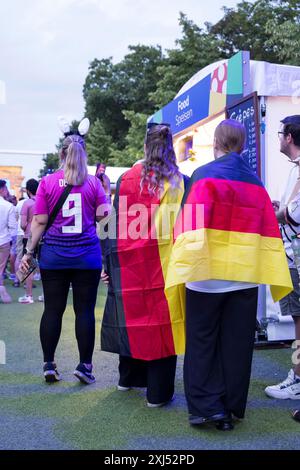 Fans mit deutschen Fahnen vor einem der Imbissstände in der Fanzone am Brandenburger Tor während des Achtelfinale-Spiels zwischen Deutschland und Stockfoto