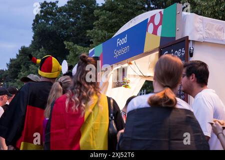 Fans mit deutschen Fahnen vor einem der Imbissstände in der Fanzone am Brandenburger Tor während des Achtelfinale-Spiels zwischen Deutschland und Stockfoto