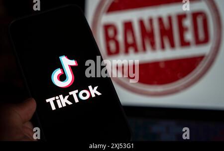 In dieser Fotoabbildung wird das Logo von TikTok auf dem Handy-Bildschirm neben dem Verbotsschild in Guwahati, Indien, am 25. April 2024 angezeigt. US-Präsident Joe Stockfoto