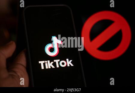 In dieser Fotoabbildung wird das Logo von TikTok auf dem Handy-Bildschirm neben dem Verbotsschild in Guwahati, Indien, am 25. April 2024 angezeigt. US-Präsident Joe Stockfoto