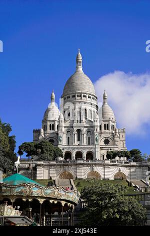 Basilika Sacre-Coeur de Motmartre, Paris, Frankreich, Europa, imposante Sacre-Coeur auf Montmartre, majestätisch am blauen Himmel über üppigem Grün Stockfoto