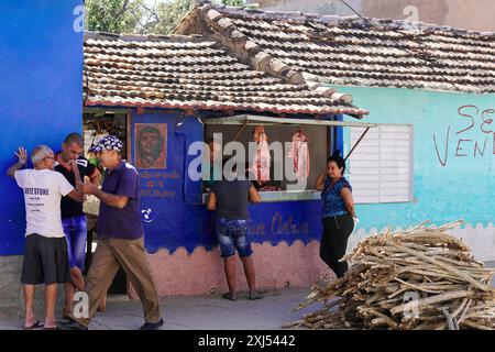 Trinidad, Kuba, Zentralamerika, mehrere Leute vor einem kleinen Laden, bemalte Wände, Holzhaufen im Vordergrund, große Antillen, Karibik Stockfoto