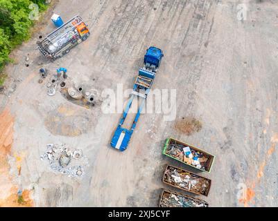 Luftaufnahme einer Baustelle mit einem LKW und Containern voller Bauschutt und mehreren Arbeitern, Abbruchstelle eines ehemaligen LKW-Transportes Stockfoto