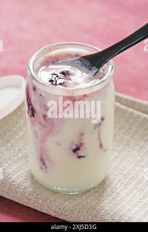 Normaler Joghurt in einem Glastopf mit brombeermarmelade Stockfoto