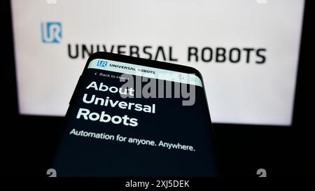 Stuttgart, Deutschland, 02.12.2024: Handy mit Webseite des dänischen Cobot-Unternehmens Universal Robots vor dem Business-Logo. Fokus oben links von Stockfoto