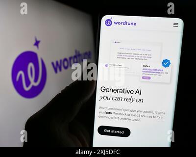 Stuttgart, Deutschland, 02.12.2024: Person mit Smartphone mit Website des Künstlichen Intelligenz-Begleiters Wordtune (AI21 Labs) mit Logo. Konzentrieren Sie sich auf Stockfoto