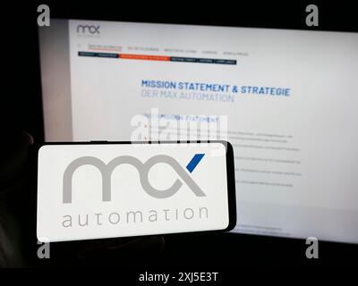 Stuttgart, Deutschland, 13.02.2024: Person mit Smartphone mit Logo des deutschen Ingenieurunternehmens MAX Automation SE vor der Website. Konzentrieren Sie sich auf Stockfoto