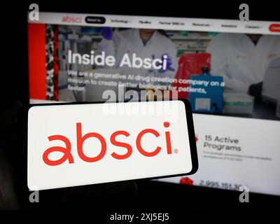 Stuttgart, Deutschland, 16.02.2024: Person, die ein Mobiltelefon mit Logo des amerikanischen Arzneimittelforschungsunternehmens Absci Corporation vor dem Business Web hält Stockfoto